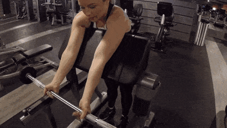 Animation of a woman doing barbell preacher curls, upper arms on the pad as she curls the bar, shown from several angles